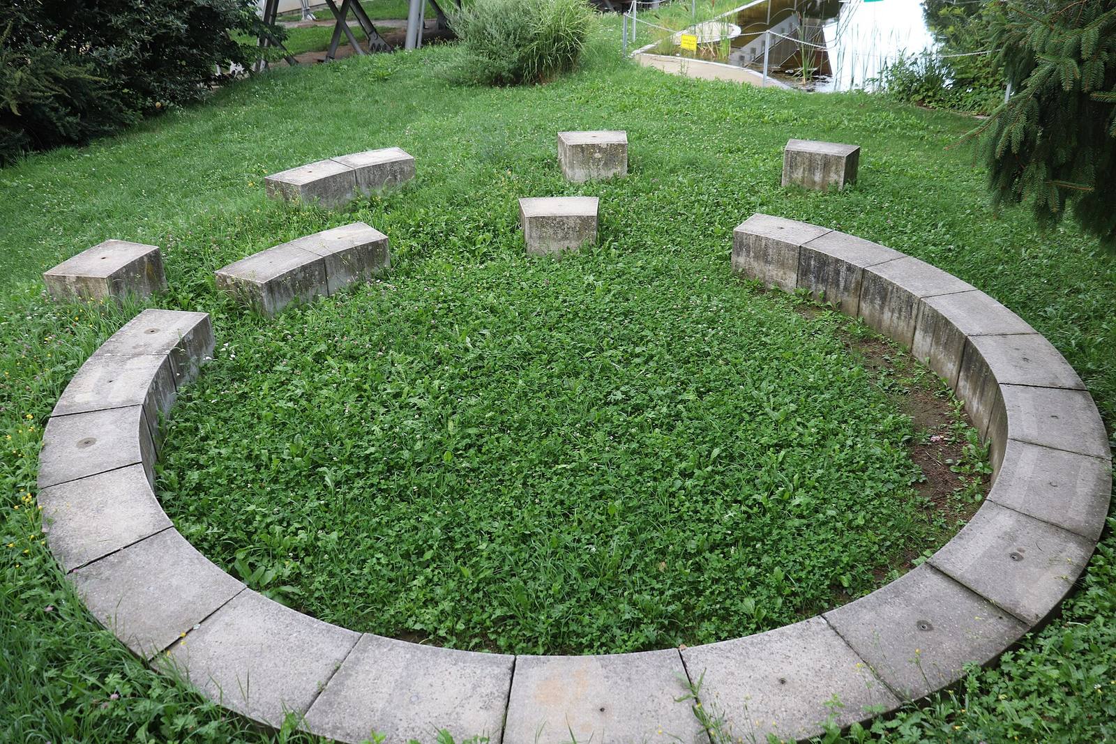 Green Classroom: circular seating wall and stone stools on a lawn