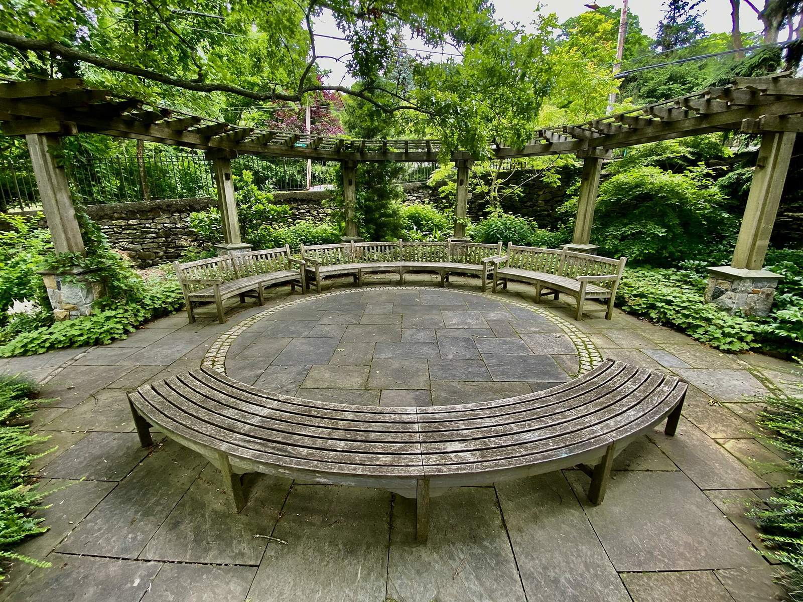 Wave Hill Shade Border: pergola with circular bench around stone floor