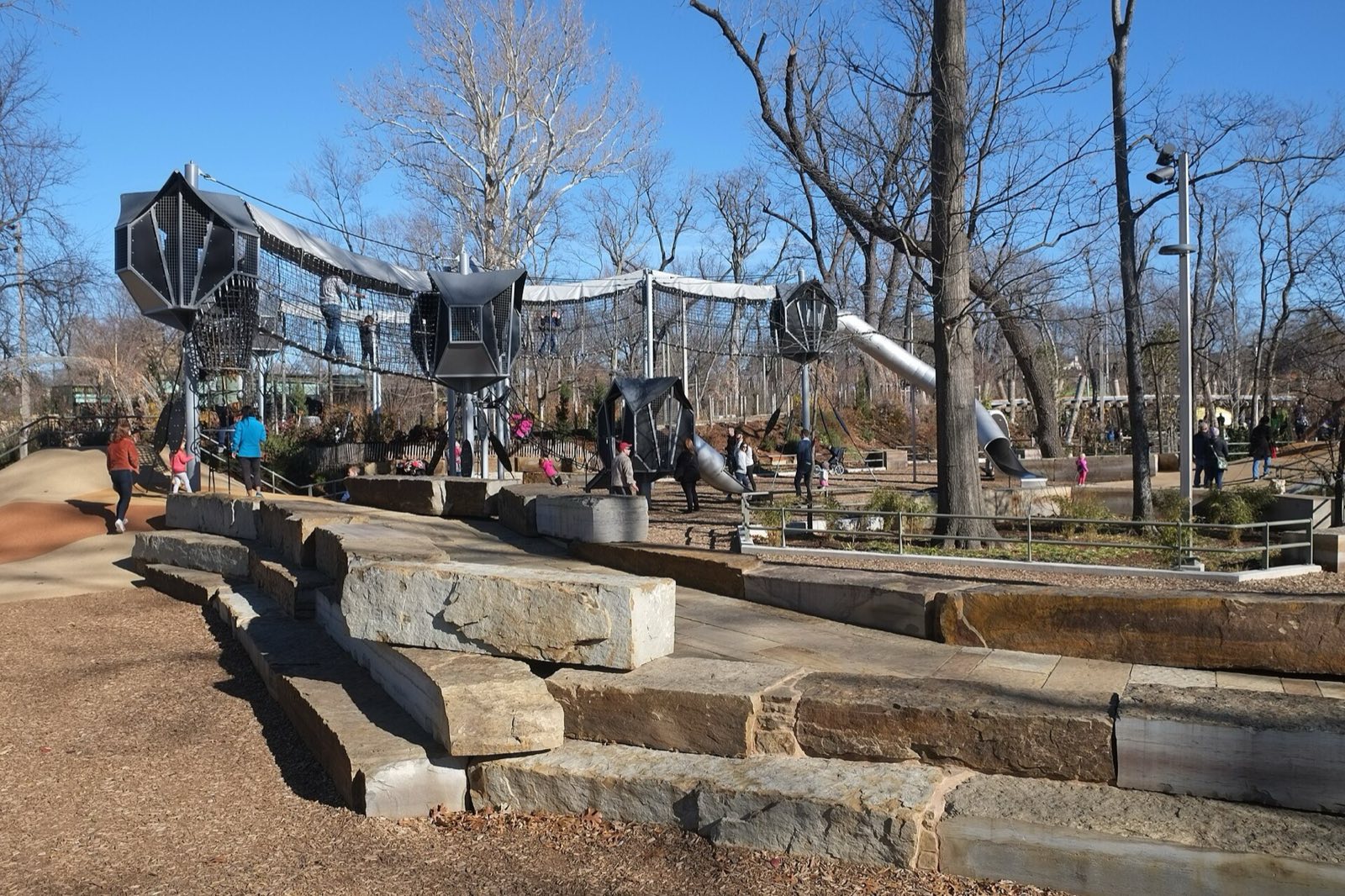 Gathering Place, stone terraces in front of rope-net towers and tube slides