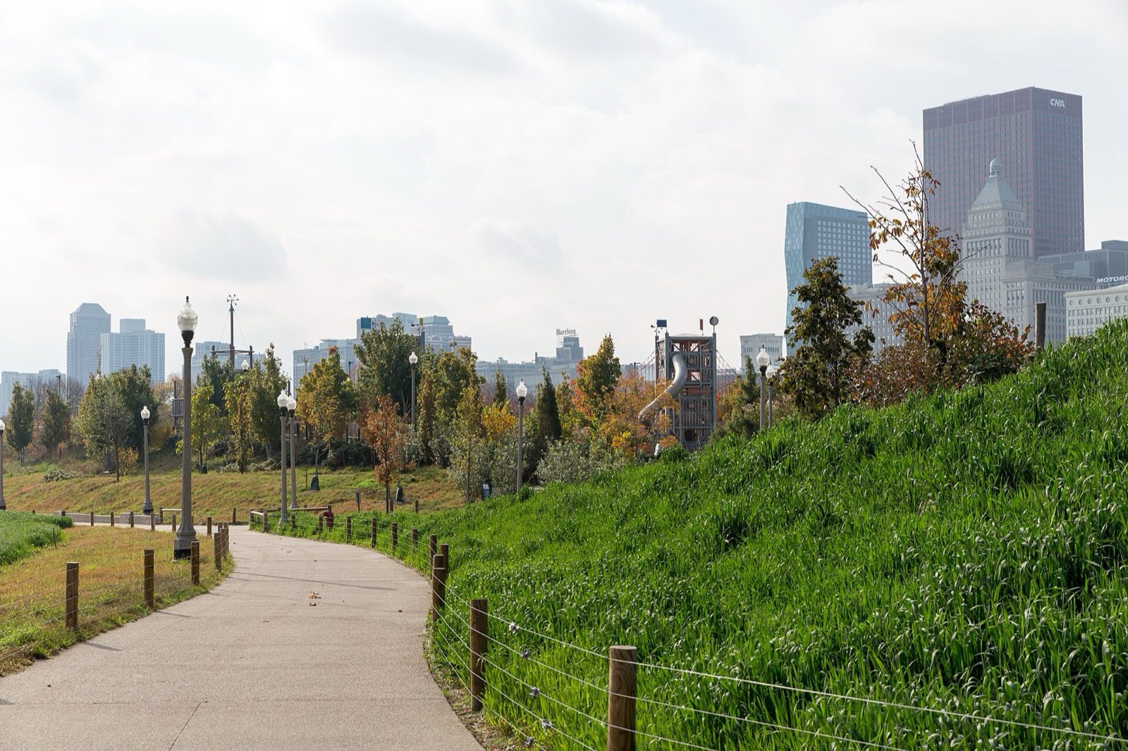 Maggie Daley Park, grass hill beside a curved path with a play tower in the distance