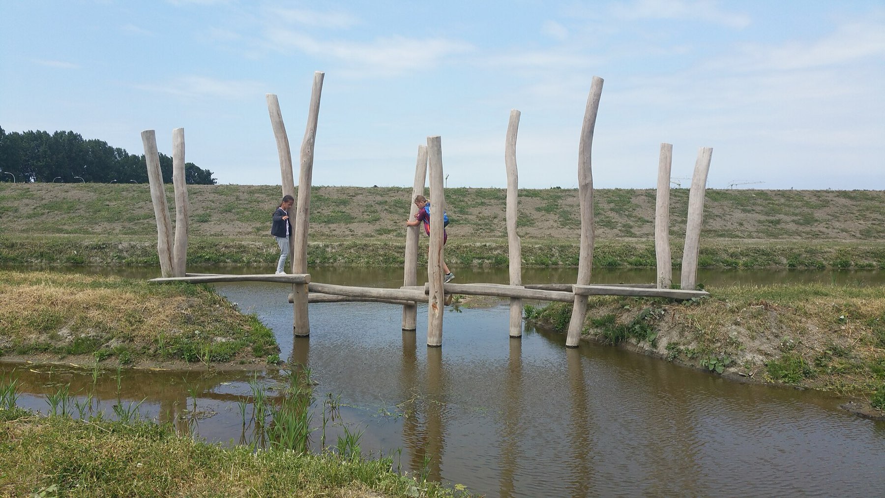 Log balance beam over a ditch with rope handrail, Netherlands